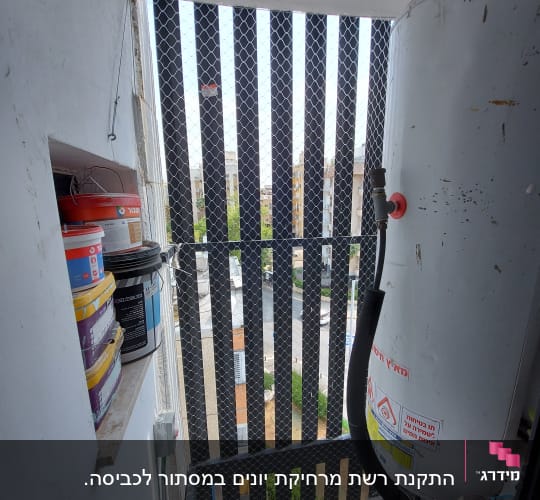 רשת מתכת מותקנת על חלון למניעת כניסת יונים.